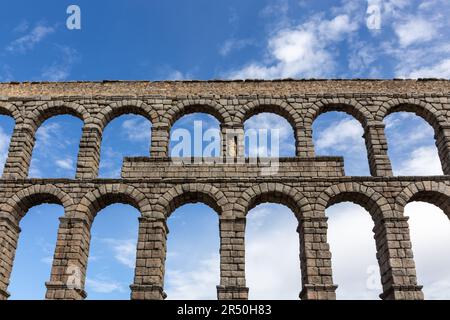 Das Aquädukt von Segovia, Spanien, antike römische Steinstruktur, Symbol von Segovia, symmetrische Sicht vor blauem Himmel. Stockfoto