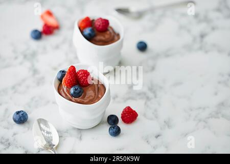 Schokoladenmousse garniert mit Erdbeeren, Heidelbeeren und Himbeeren Stockfoto