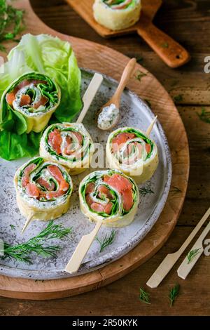 Geräucherte Lachsbrötchen mit Frischkäse und Salat auf Stöcken Stockfoto