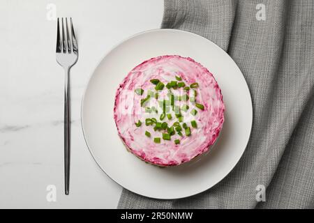 Hering unter Pelzmantel Salat serviert auf weißem Tisch, flach liegend. Traditionelles russisches Gericht Stockfoto