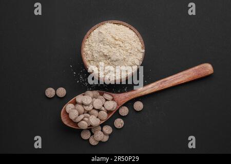 Verschiedene Arten von Bierhefe auf schwarzem Hintergrund, flach liegend Stockfoto