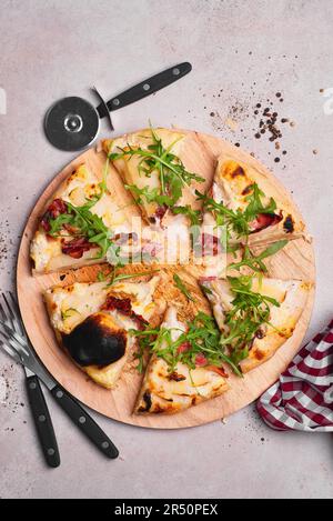 Pizza Bianca mit Gorgonzola, Birnen, Walnüssen, Schinken und Rucolasalat Stockfoto