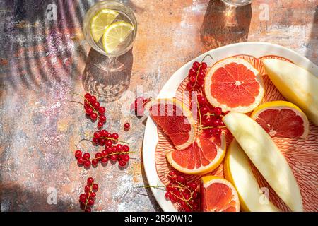 Aprikose, rote Strömungen, rote Grapefruit und Mandel mit Gläsern aromatisiertem Wasser Stockfoto