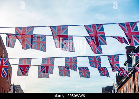 Union Jack Bolling, das zwischen Gebäuden hängt, eine Show des Patriotismus, zur Feier der Krönung von König Karl III Stockfoto