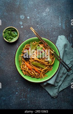 Gebratene udon-Nudeln mit Huhn, Gemüse und Pilzen Stockfoto