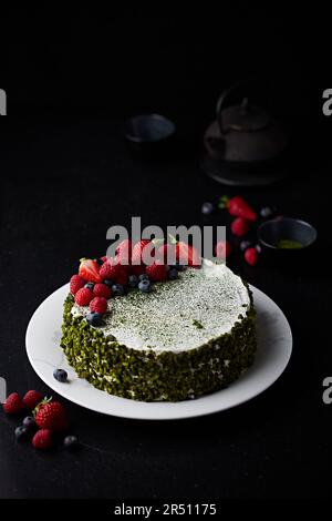 Matcha-Mille-Feuille-Kuchen mit Pistazien und Sommerbeeren Stockfoto