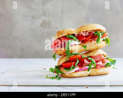 Serrano-Sandwich mit Tomaten und Rucolasalat Stockfoto