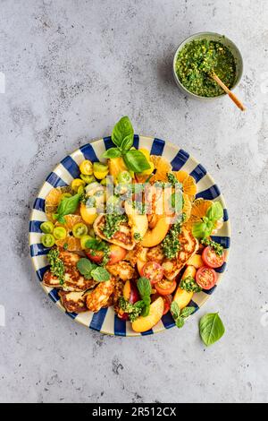 Halloumi-Salat mit Nektarinen, Orangen, Tomaten und Pesto Stockfoto