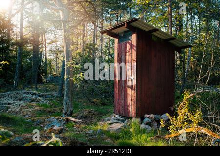 Hölzerne Außentoilette im Wald Stockfoto