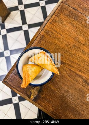 Zwei Samosas in einer Schüssel auf dem Tisch (Mumbai, Indien) Stockfoto