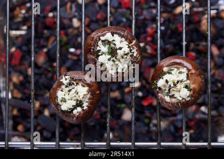 Gegrillte gefüllte Pilze auf einem Grillgitter Stockfoto