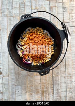 Kichererbsen mit Gewürzen und Zwiebeln in einem holländischen Ofen Stockfoto