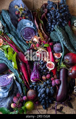 Herbststille mit Gemüse und Obst in Lila Stockfoto