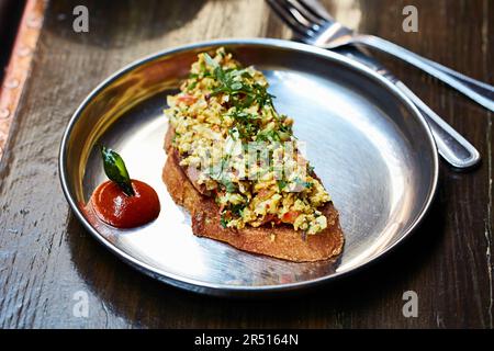 Indisch gewürzte Rühreier auf Toast Stockfoto