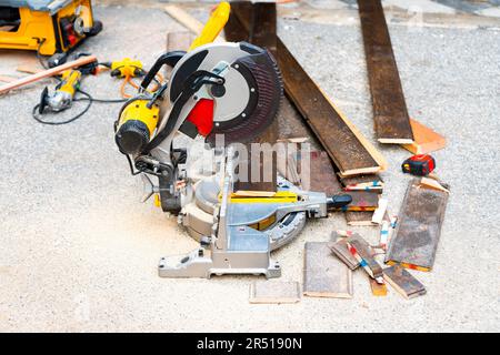 Frisch geschnittene Holzbohlen mit einer Gleitmittel-Gehrungssäge, die im Freien mit Sägemehl bedeckt ist. Hintergrund für Hausrenovierungen. Stockfoto