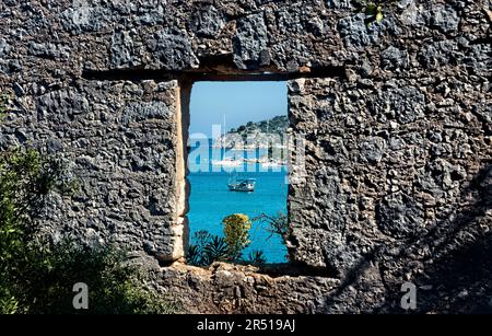 Yachten durch Burgruinen auf der Lykischen Straße, Üçağız, Türkei Stockfoto