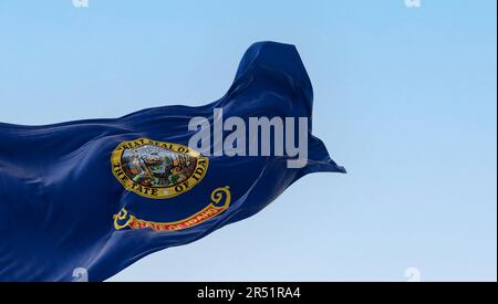 Idaho Staatsflagge flattert im Wind. Blauer Hintergrund mit Staatssiegel und roter Streifen mit goldenem Text des Bundesstaats Idaho. Rendern der 3D-Darstellung. Stockfoto