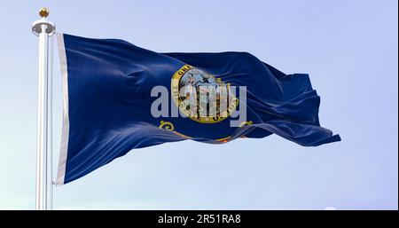 Idaho Staatsflagge flattert im Wind. Blauer Hintergrund mit Staatssiegel und roter Streifen mit goldenem Text des Bundesstaats Idaho. Rendern der 3D-Darstellung. Stockfoto