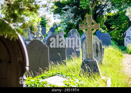 Keltisches Kreuz im Friedhof von Eglwys Sant Tysilio / St. Tysilio's Kirche auf einer Gezeiteninsel in der Menai Straights, Anglesey, Wales Stockfoto