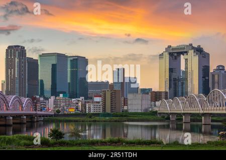 Osaka, die japanische Skyline in Umeda am frühen Morgen von der anderen Seite des Yodogawa River. Stockfoto