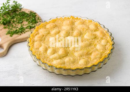 Gebackene Polenta in einer Backform und Petersilie auf hellgrauem Hintergrund. Leckeres italienisches Essen. Stockfoto