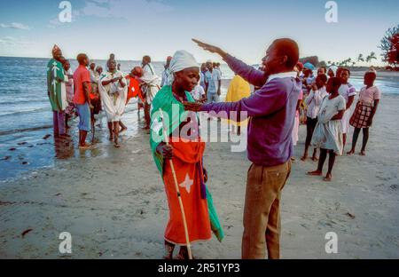 Mosambik, ein Medizinmann versucht, einen bösen Geist von einer Frau am Strand von Maputo zu exorzieren. Stockfoto