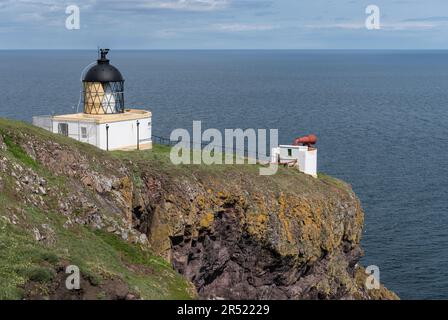 St Abbs Head Leuchtturm und Nebelhorn auf Felsenklippen mit flachem, ruhigem blauen Meer und Horizont im Hintergrund. Stockfoto