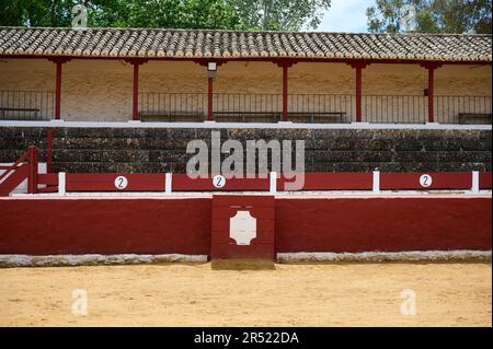 Rote Backsteinmauer mit Inschrift und Steinmauer mit Galerien der berühmten Stierkampfarena von Madrid Spanien mit gefliestem Dach unter blauem Himmel Stockfoto