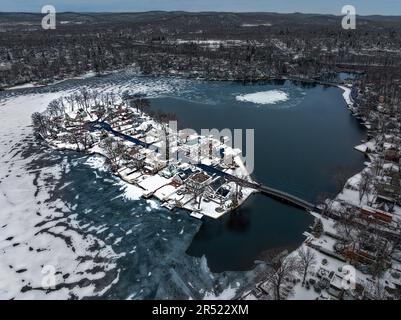 Frozen NJ Island – die Indian Island in Denville, New Jersey, nach einem Schneefall im Winter aus der Vogelperspektive aus der Vogelperspektive. Das Wasser ist im l teilweise gefroren Stockfoto