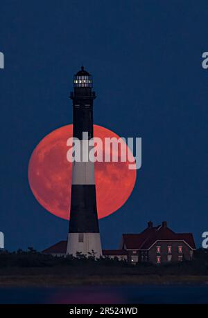 Fire Island Lighthouse Moonrise - der Vollmond erhebt sich hinter dem Fire Island Lighthouse. Der Fire Island Lighthouse ist der höchste Leuchtturm auf Lon Stockfoto