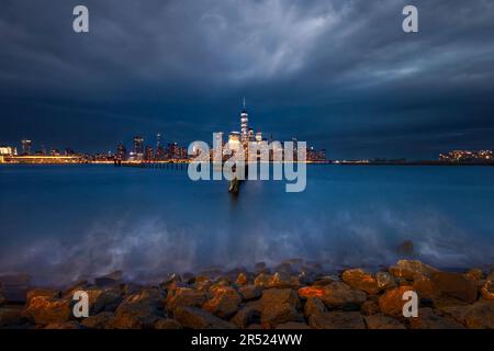 Skyline von Lower Manhattan NYC - die beleuchtete Skyline der Innenstadt von New York City während der Aussichtsperiode. Hoch stehend entlang vieler Wolkenkratzer in t Stockfoto