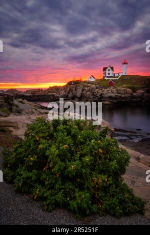 Nubble Light Sunrise ME - Blick auf einen wunderschönen, dramatischen Himmel mit der aufgehenden Sonne hinter dem legendären Nubble Lighthouse am Cape Neddick in Y Stockfoto