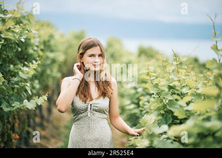 Außenporträt eines hübschen jungen Teenagers, das in Weinbergen wandert, Sommeraktivitäten Stockfoto