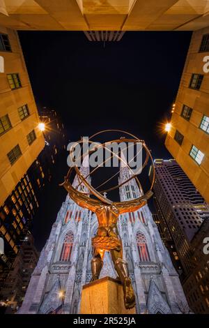 Saint Patricks Cathedral NYC - Blick hinter der Atlasstatue auf die gotische Wiedergeburt und den englisch-gotischen Architekturstil der Saint Patrick Cathedra Stockfoto