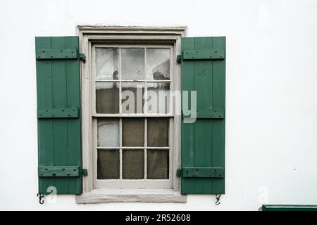 Grüne Fensterläden an einem Fenster - ältestes Haus St. Augustine Florida. Weiße Wände Stockfoto