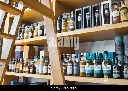 Regale mit hochwertigen Single-Malt- und Whisky-Flaschen in einem Fachgeschäft für Spirituosen Stockfoto