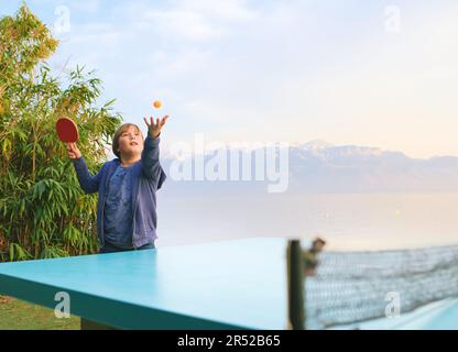 Ein Junge, der Tischtennis am See spielt, ein aktiver Lebensstil für Kinder Stockfoto