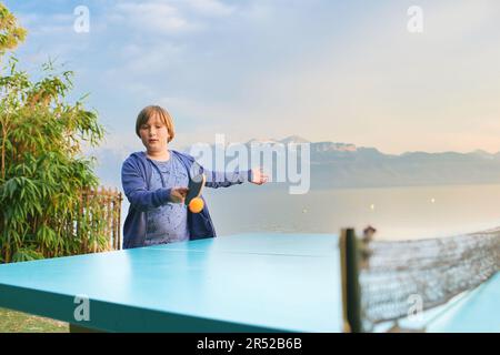 Ein Junge, der Tischtennis am See spielt, ein aktiver Lebensstil für Kinder Stockfoto