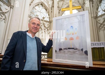 31. Mai 2023, Mecklenburg-Vorpommern, Greifswald: Tilman Beyrich, Pastor in St. Nikolai Kathedrale, zeigt ein Design des dänisch-isländischen Künstlers 'lafur Elíasson. Neben einem umfangreichen Kulturprogramm wird der 250. Geburtstag des Malers Caspar David Friedrich im kommenden Jahr auch bleibende Spuren in seiner Heimatstadt Greifswald hinterlassen. Die neuen Ostfenster in der Kathedrale sollen im April eröffnet werden. Der international bekannte zeitgenössische Künstler Elíasson entwirft ein modernes Kirchenfenster für St. Nikolai Kathedrale - das Taufwerk der berühmten Romantik. Stockfoto