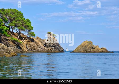 Weißes Schiff zwischen Felsen. Blaues Meer und Himmel. Stockfoto