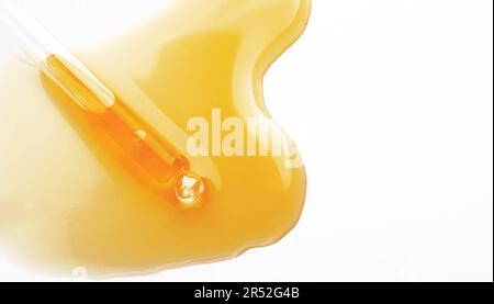 Gelbe Serum- oder Olivenöltropfenstruktur auf weißem Hintergrund isoliert, transparente Schaumgel-Kosmetikprobe. Goldene flüssige Säurecreme oder Honig Stockfoto