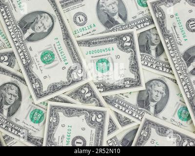 Zahlreiche zwei-Dollar-Scheine, die flach auf einem Tisch liegen – ungerade, einzigartige US-Währung Stockfoto