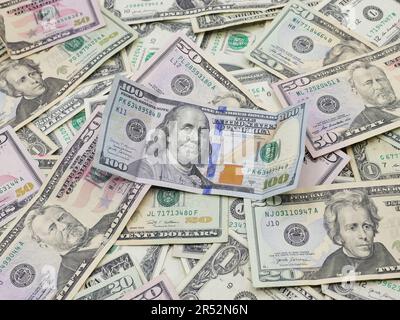 Zahlreiche Hundert-, fünfzig-, zwanzig-, ein- und zwei-Dollar-Scheine, die flach auf einem Tisch liegen – Ungerade eindeutige US-Währung Stockfoto