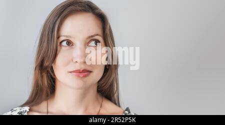 Eine wunderschöne Frau mittleren Alters, die nach Side schaut. Nahaufnahme Porträt auf hellem Hintergrund Stockfoto