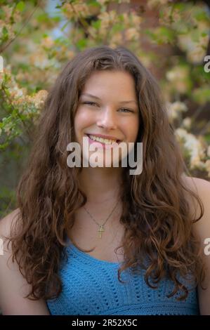 Schöne junge lächelnde Frau mit langen braunen Haaren Stockfoto