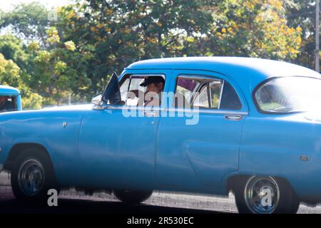 Ein Kubaner sitzt in seinem alten Auto an einer Ampel in Havanna, Kuba. Stockfoto