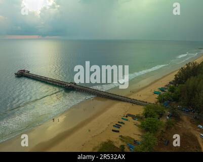 Aus der Vogelperspektive die Brücke erstreckt sich bei schönem Sonnenuntergang bis ins Meer. Atemberaubende Wolken, die sich am blauen Himmel bewegen. Wunderschöne Sonnenuntergangslandschaft, herrliches Licht der Natur Stockfoto