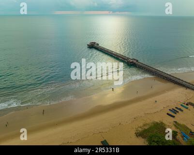 Aus der Vogelperspektive die Brücke erstreckt sich bei schönem Sonnenuntergang bis ins Meer. Atemberaubende Wolken, die sich am blauen Himmel bewegen. Wunderschöne Sonnenuntergangslandschaft, herrliches Licht der Natur Stockfoto