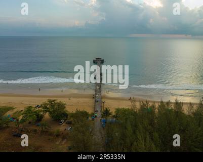 Aus der Vogelperspektive die Brücke erstreckt sich bei schönem Sonnenuntergang bis ins Meer. Atemberaubende Wolken, die sich am blauen Himmel bewegen. Wunderschöne Sonnenuntergangslandschaft, herrliches Licht der Natur Stockfoto