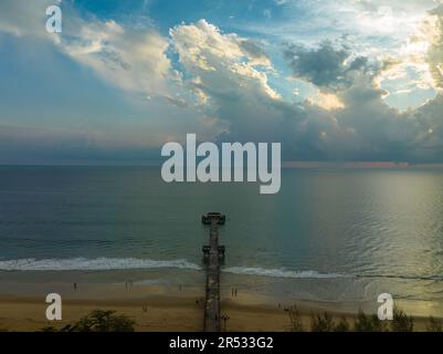 Aus der Vogelperspektive die Brücke erstreckt sich bei schönem Sonnenuntergang bis ins Meer. Atemberaubende Wolken, die sich am blauen Himmel bewegen. Wunderschöne Sonnenuntergangslandschaft, herrliches Licht der Natur Stockfoto